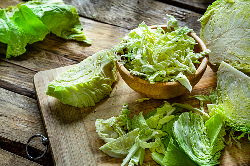 Fresh organic shredded cabbage in a wooden bowl shot on rustic table. High resolution 42Mp studio digital capture taken with Sony A7rII and Sony FE 90mm f2.8 macro G OSS lens