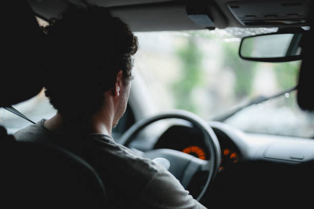 istock A young caucasian guy sits behind the wheel while driving a car. 2147548226