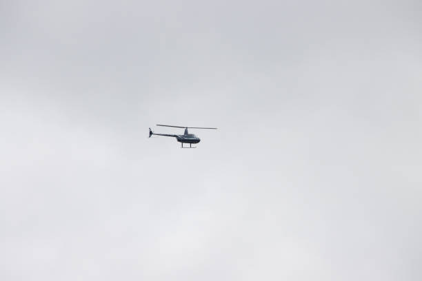 Military Helicopter Silhouette Flying over a Dark Sky