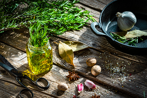 Extra virgin olive oil, rosemary and spices on rustic table. High resolution 42Mp studio digital capture taken with Sony A7rII and Sony FE 90mm f2.8 macro G OSS lens