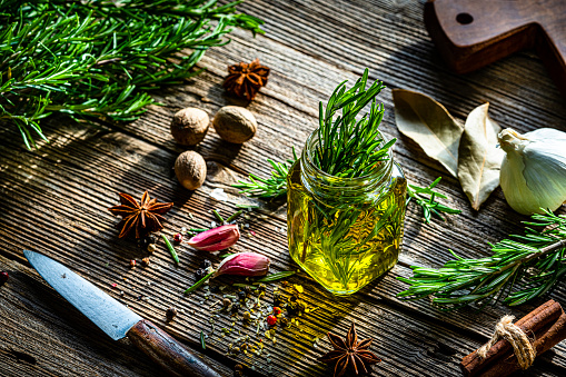 Extra virgin olive oil, rosemary and spices on rustic table. High resolution 42Mp studio digital capture taken with Sony A7rII and Sony FE 90mm f2.8 macro G OSS lens