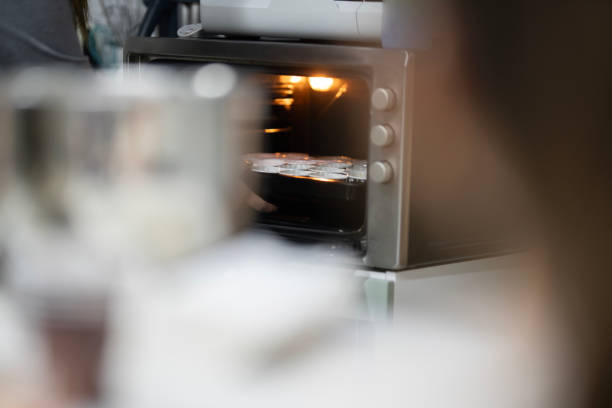 There are two metal containers on the kitchen counter. There is a bakery image in the background