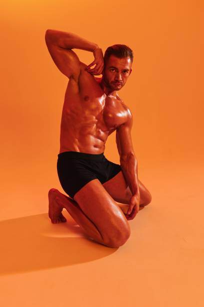 istock Man bodybuilder boxer muscle workout with naked torso with abs posing in studio. Advertising, sports, active lifestyle, colored yellow light, competition, challenge concept. 2147550705