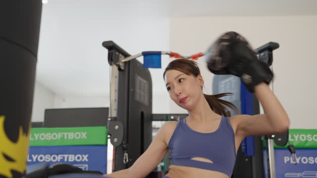 A woman is boxing in a gym