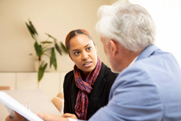 istock Two business colleagues sitting at a table with paperwork and having a discussion 2147551994