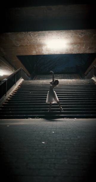 istock Dancing, night and woman with ballet, training and artistic with performance, light and talent. Person, dancer and girl with workout, culture and practice with routine, staircase and ballerina 2147552039