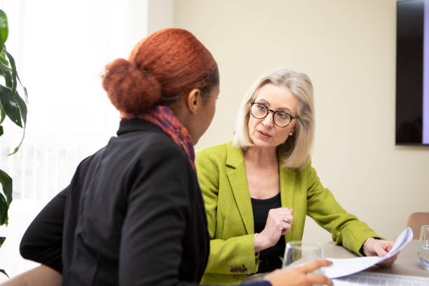 istock Two business colleagues sitting at a table with paperwork and having a discussion 2147552122