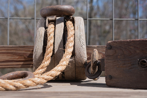 Two antique block and tackle with hooks and rope.