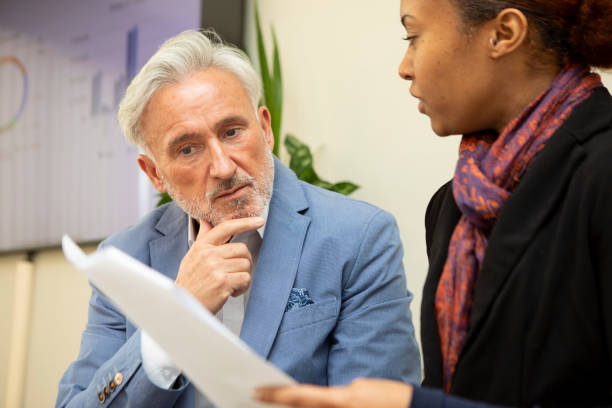 istock Two business colleagues sitting with paperwork and having a discussion 2147552404
