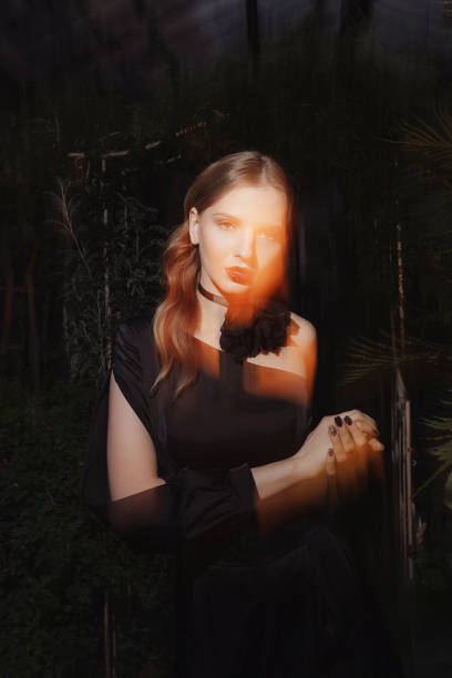 istock Female model illuminated by a light source against a background of foliage 2147552406