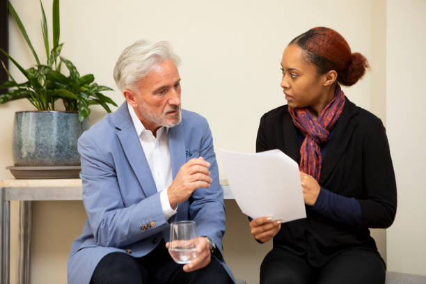 istock Two business colleagues sitting with paperwork and having a discussion 2147552434