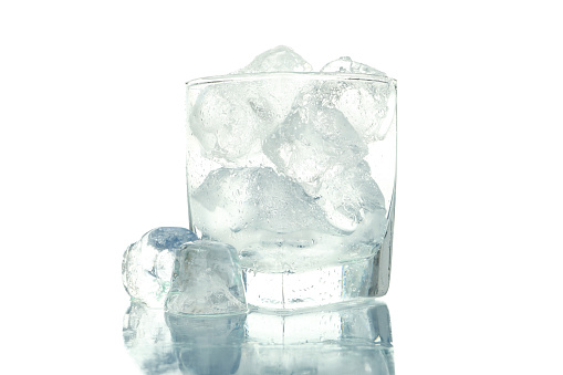 A large rectangle of melting clear ice, on white background with a mirror reflection. Creative concept of cold purity.