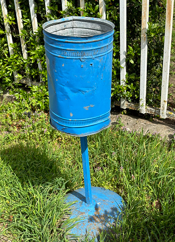 Blue metal trashcan on the street