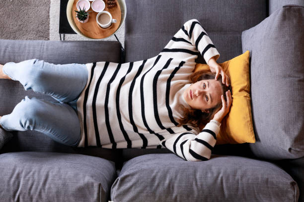 istock Top view depressed young woman lying on sofa 2147554327