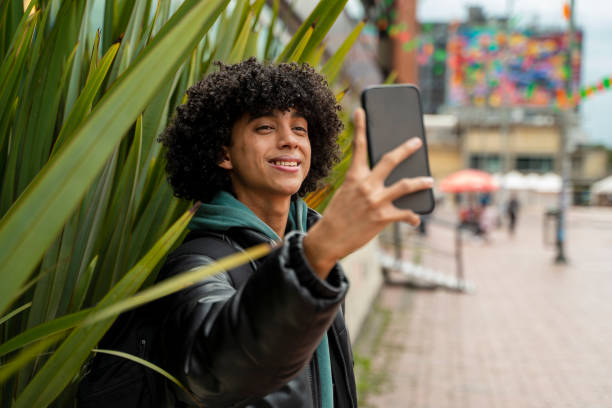 istock Man smiling at his phone camera to send a photo via text message 2147556134