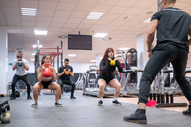 istock Group kettlebell workout in gym with individual coaching and diverse participants. 2147556791