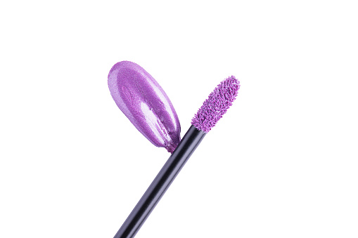 Purple liquid lipstick and applicator isolated on white background. Swatch of lavender lip gloss. Top view, flat lay, copy space