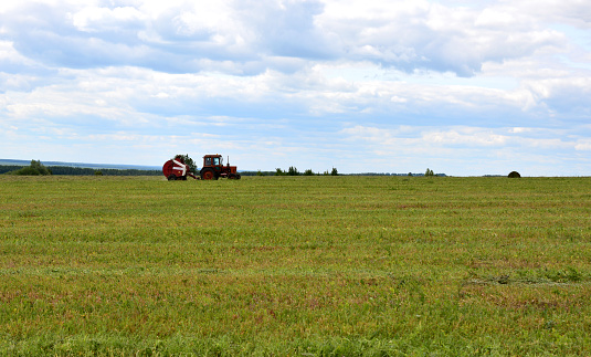 a red tractor working in the field copy space