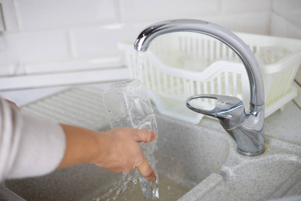 istock A woman rinses plastic bottles in the kitchen before sending them for plastic recycling. A woman sorts and washes household plastic waste for recycling. Zero waste, ecology. 2147561512