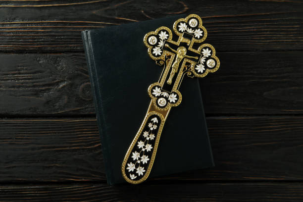 Wooden rosary cross hanging from blooming tree branch, symbolizing faith, spirituality, and renewal during spring season.