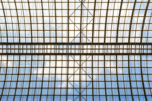 Sky with clouds through the glass arched ceiling of a modern building. Architectural concept of open space.