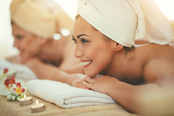 Two cute young women are enjoying during a skin care treatment at a spa.