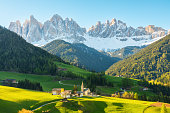 Sunny landscape with Santa Magdalena village against the Geisler mountains covered with snow at sunrise, Val Di Funes in Dolomites mountains, South Tyrol, Italy
