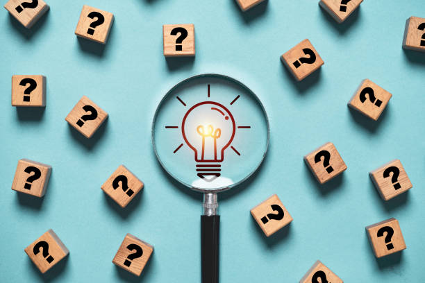 istock Glowing light bulb inside magnifier glass among question mark for focus and concentrate of creative thinking idea and problem solving concept. 2147566591