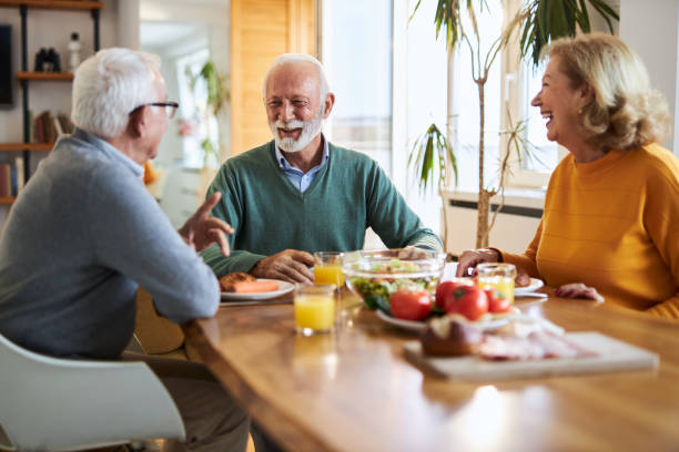 istock Group of happy senior  friends talking while having a meal at dining table. 2147567993
