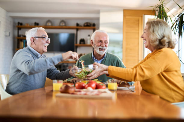 istock Group of happy senior friends talking while having a meal at dining table. 2147568297