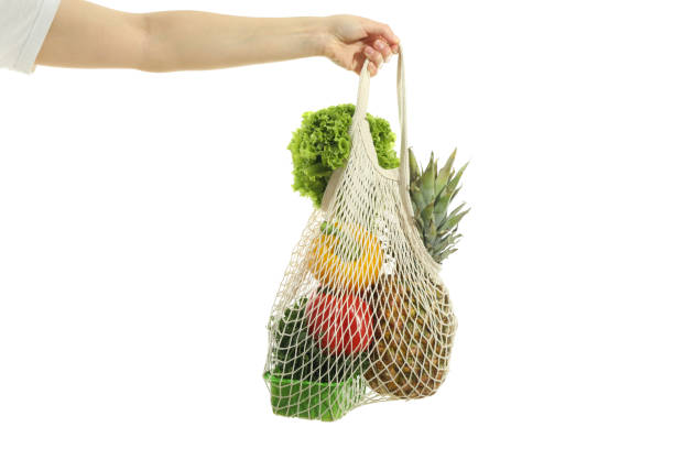istock Female hand holds string bag with food, isolated on white background 2147572851