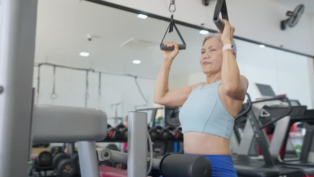 A woman is lifting weights in a gym