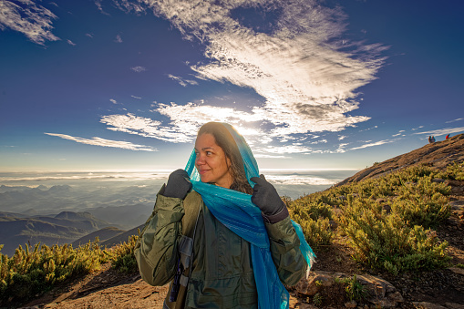 Woman happy to achieve the right goal of reaching the top of the mountain.