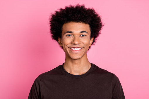 Closeup photo of young cheerful guy in brown t shirt toothy beaming smile model with funny chevelure isolated on pink color background.