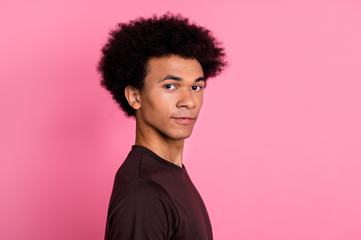 Portrait of young handsome optimistic smiling funky man chevelure wavy hair wearing brown shirt isolated on pink color background.