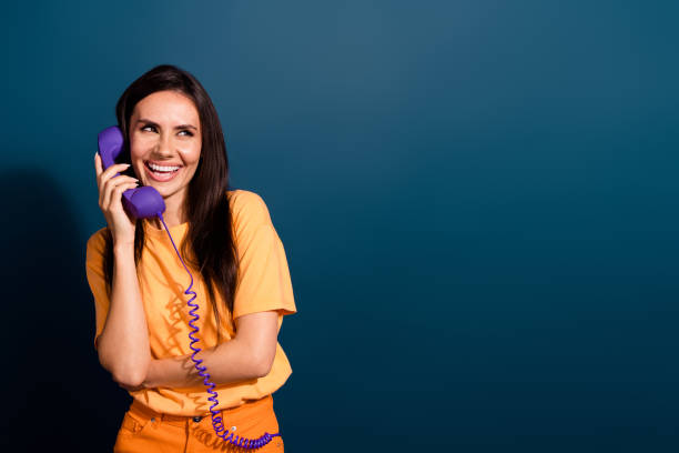 istock Photo of laughing girlfriend has conversation on phone looking empty space talking to boyfriend isolated over dark blue color background 2147576670