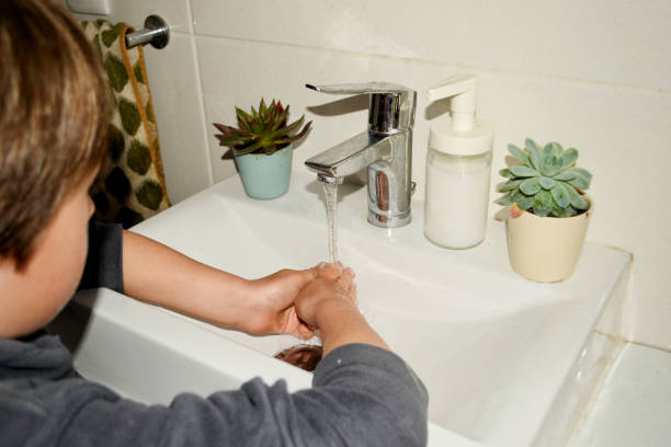 istock boy washes his hands in the sink 2147578500