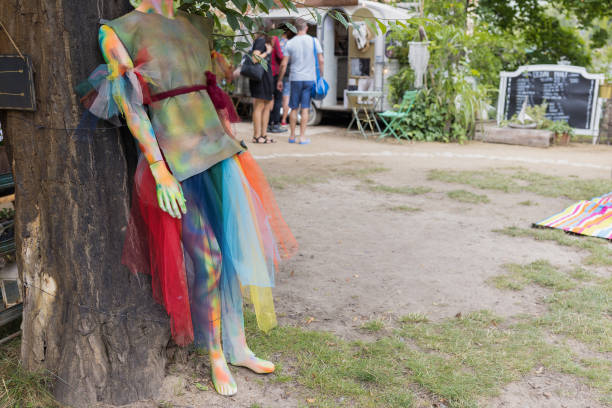 manichino colorato in abito arcobaleno all'aperto al mercato - eclectic community foto e immagini stock