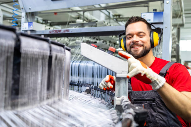 istock Skilled factory worker operating sewing machine for plastic bags production. 2147581981