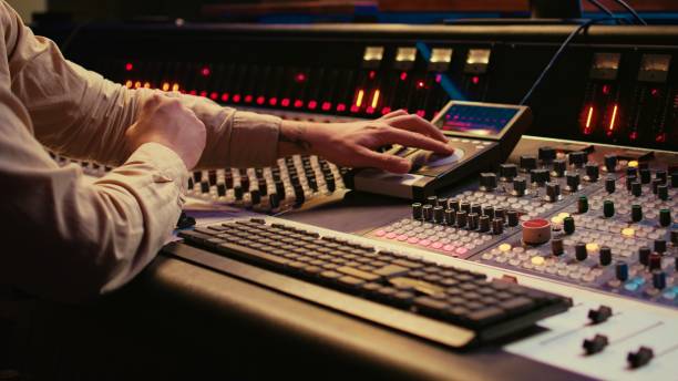 istock Audio technician uses mixing console and faders in control room 2147582736