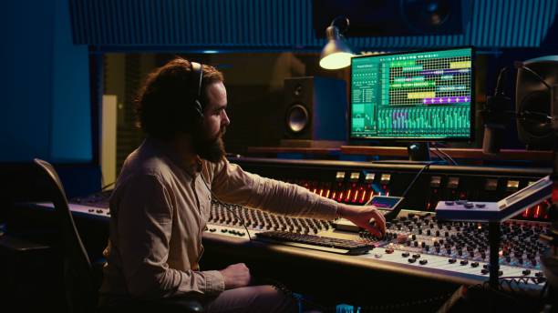 istock Mixing engineer pressing sliders on control desk to balance tracks 2147582833