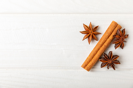 Cinnamon sticks and anise on a textured background. Cinnamon roll and star anise. Spicy spice for baking, desserts and drinks. Fragrant ground cinnamon.Place for text. copy space.