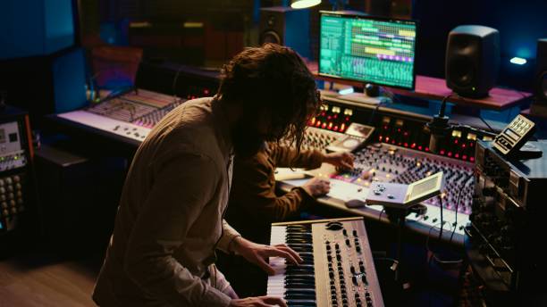 istock Skilled musician performing in control room at studio and recording tracks 2147583172