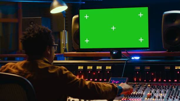 istock Audio technician works on music post production with greenscreen in control room 2147583788
