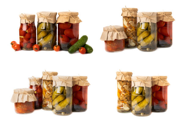 Canned tomatoes in a jar isolated on a white background. Pickled jars cherry tomatoes in a glass jar.Food preservation for autumn or winter. Home storage. Canning, fermentation concept.