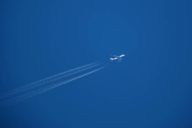 istock Airplane in the blue sky with contrails. 2147584371