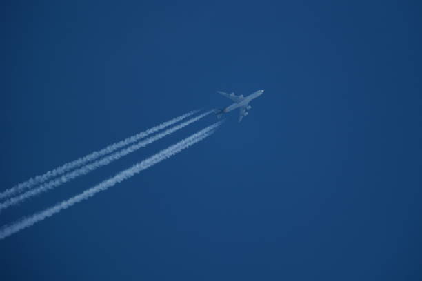 istock Airplane in the blue sky with contrails. 2147584896
