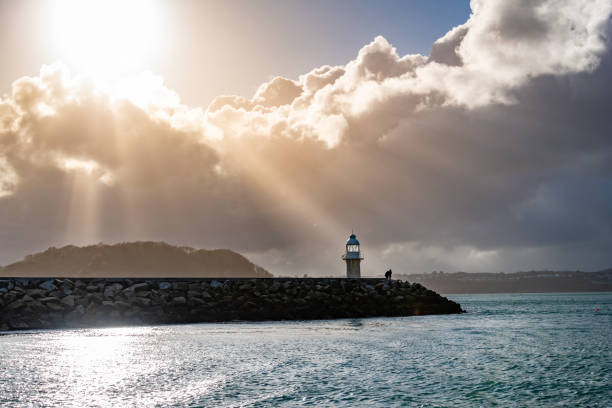 Low sun over the Lighthouse on Brixham Harbour Wall