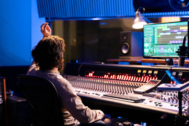 istock Sound designer counting down for singer in vocal booth to start performance 2147586161