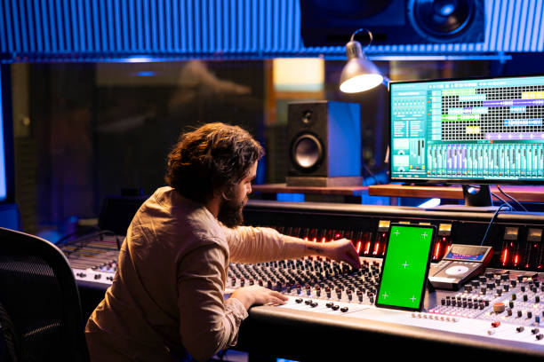 istock Professional audio technician recording tracks next to isolated display 2147586575